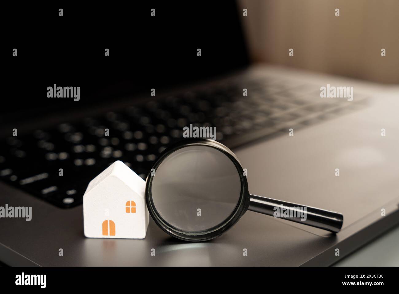 Casa e lente d'ingrandimento sulla tastiera del laptop. Il concetto di ricerca di alloggi via Internet. Trova un appartamento in affitto online. Valu. Proprietà Foto Stock
