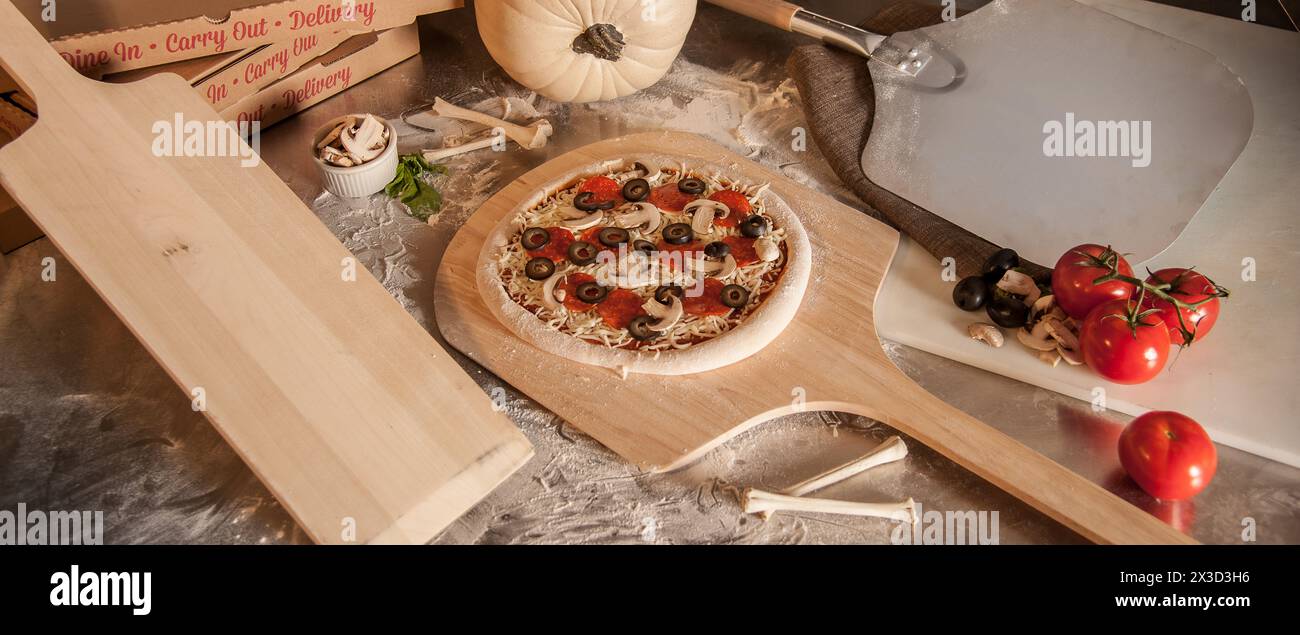 Pizza cruda preparata per il forno, con condimenti freschi Foto Stock
