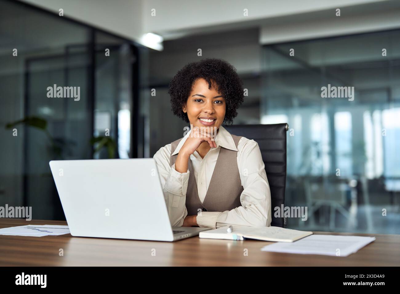 Giovane felice donna d'affari africana professionale alla scrivania dell'ufficio, ritratto. Foto Stock