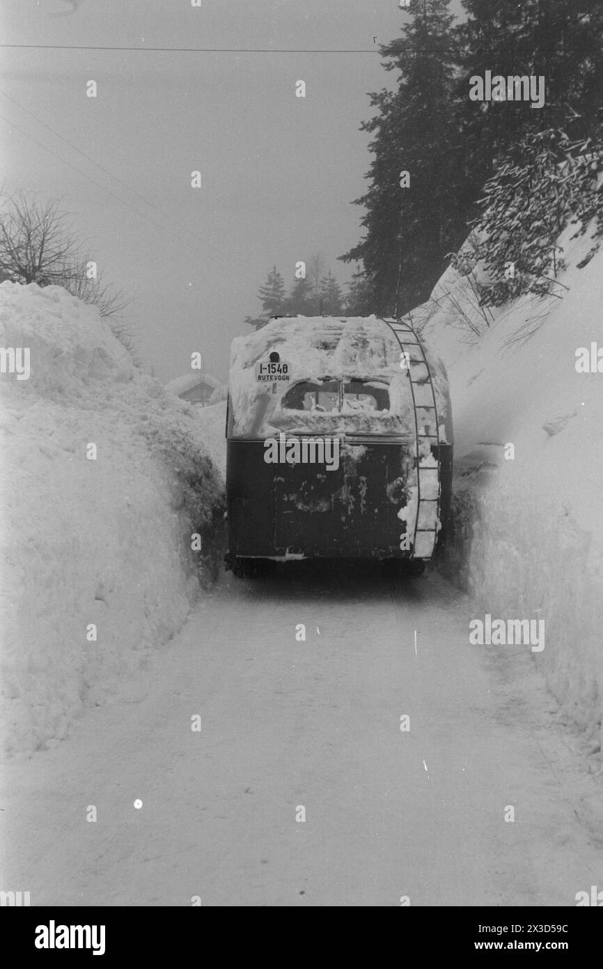 Effettivo 05- 1951: Norvegia meridionale coperta di neve. Lungo le strade, i bordi dell'aratro alti quattro cinque metri, la neve è così alta che si può facilmente uscire dal secondo piano e le persone devono costantemente salire sui tetti per liberare la neve da lì. Ecco come appare la strada da Vegårshei a Tvedestrand. Due volte quest'inverno è stato bloccato dalla neve, e i bordi dell'aratro sono in molti punti fino a cinque metri di altezza. Una lotta per tenerla aperta! Foto: Arne Kjus / Aktuell / NTB ***la foto non viene elaborata*** il testo dell'immagine viene tradotto automaticamente Foto Stock