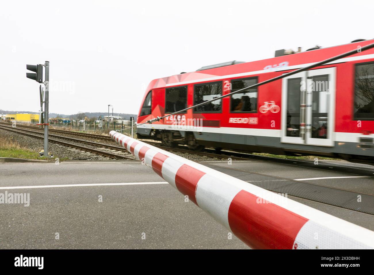 Passaggio di un treno locale a un passaggio a livello con barriere, Germania, Renania settentrionale-Vestfalia, Weilerswist Foto Stock