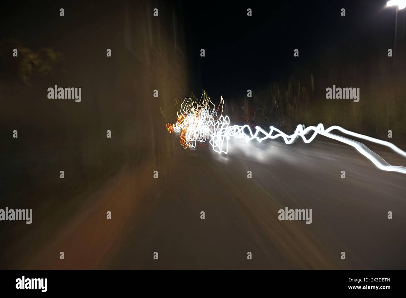Movimento fari auto offuscati tranquilla strada notturna Ely Foto Stock
