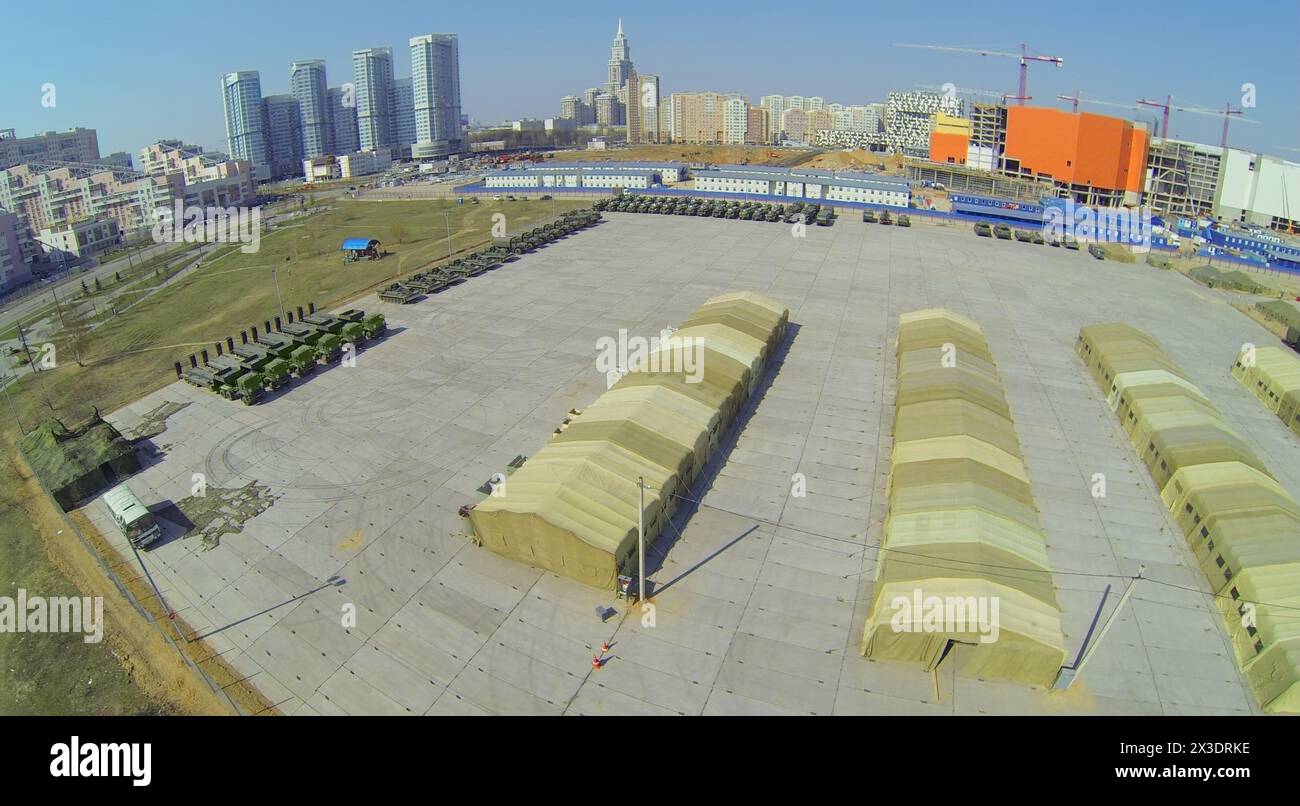 MOSCA, RUSSIA - 20 APRILE 2014: Base militare con tende e macchine preparate per la Parata del giorno della Vittoria e cantiere del centro commerciale Aviapark Foto Stock