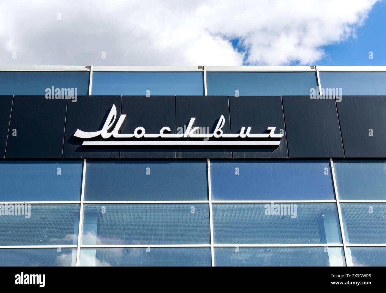 Samara, Russia - 16 aprile 2024: Showroom auto di un marchio Moskvich. Cartello ufficiale della concessionaria di Moskvich sul muro dell'edificio degli uffici Foto Stock