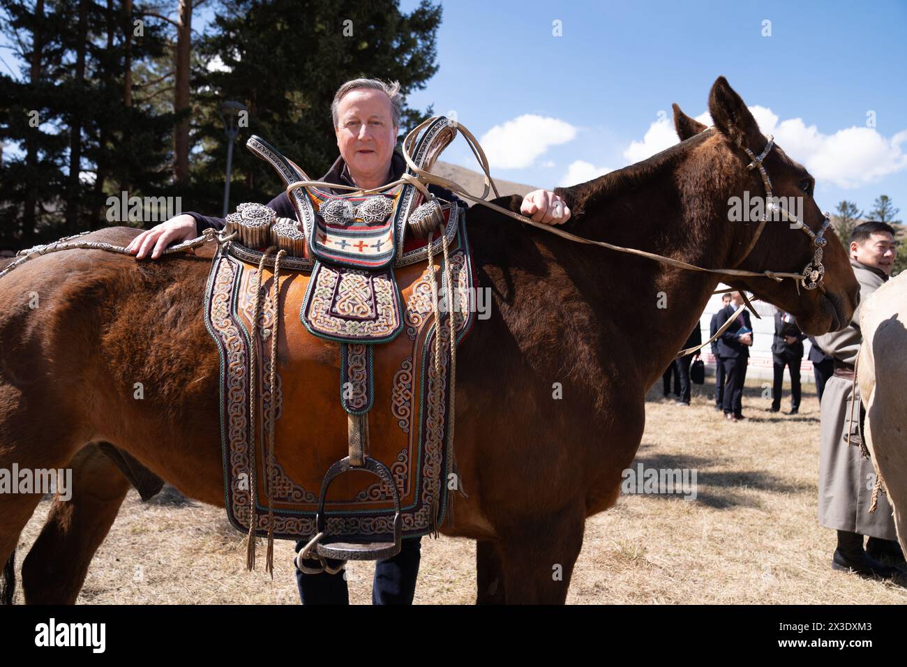 Il Segretario degli Esteri Lord David Cameron posa per una foto con uno dei cavalli del primo Ministro della Mongolia durante una visita al complesso Ikh Tenger a Ulan Bator, Mongolia, l'ultimo giorno del suo tour di cinque giorni nella regione dell'Asia centrale. Data foto: Venerdì 26 aprile 2024. Foto Stock