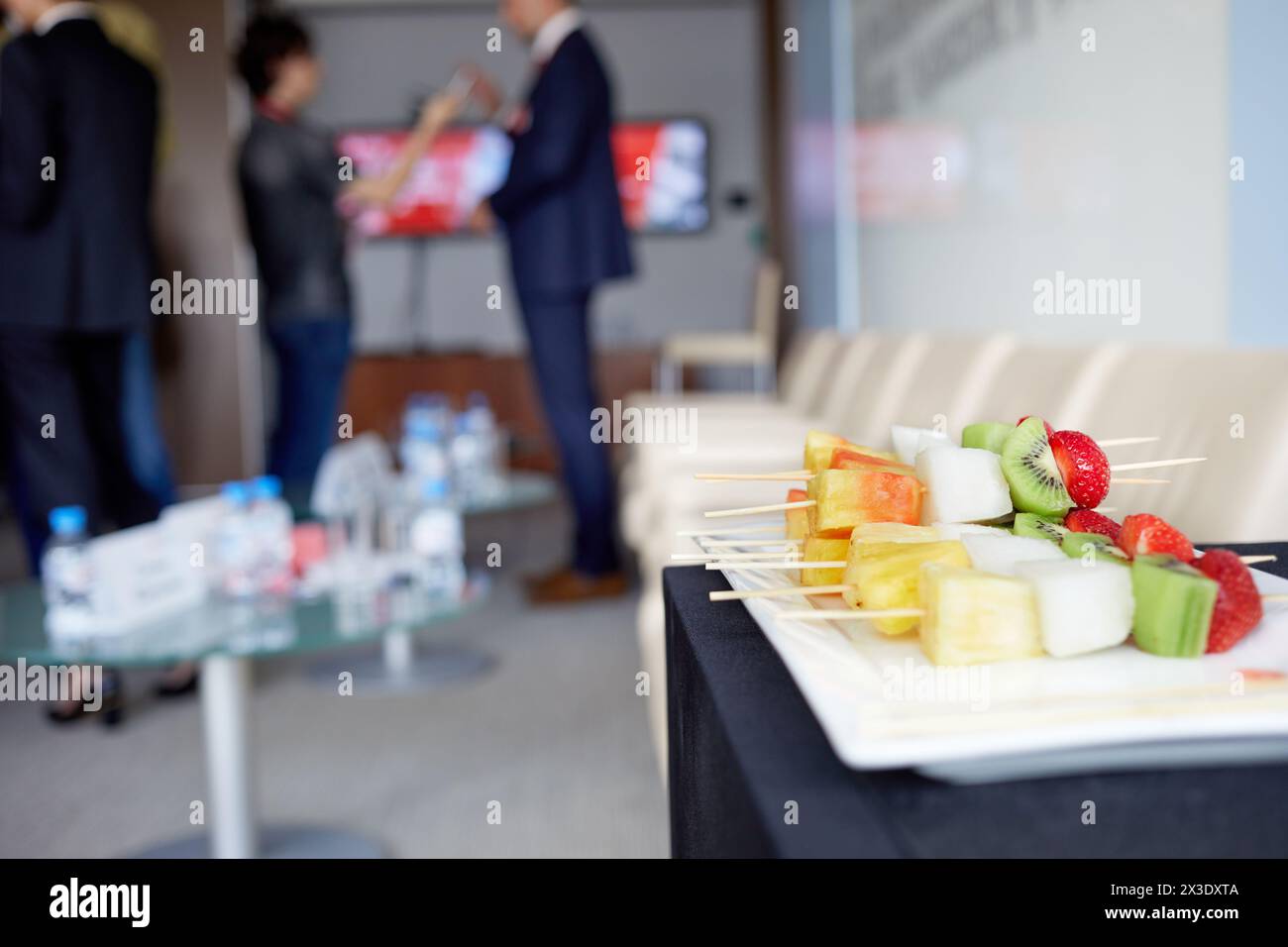 Spuntini di frutta su spiedini di legno sul piatto nella sala conferenze. Foto Stock