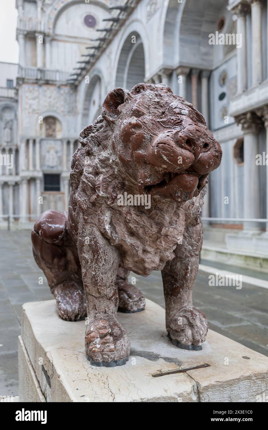 Statua del Leone in Piazzetta dei Leoncini - Piazza dei Leoni accanto al lato nord della Basilica di San Marco a Venezia. Scultura in marmo rosso b Foto Stock