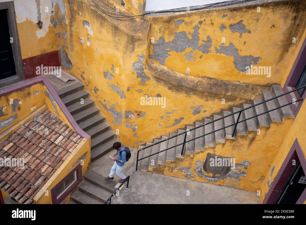Una vista aerea di gradini all'interno di un cortile interno al forte di Sao Tiago (giallo), il 22 aprile 2024, a Funchal, Madeira, Portogallo. Originariamente costruito per proteggere la costa dalla pirateria durante il XVI-XVII secolo durante il regno di Filippo i del Portogallo. Il forte è stato utilizzato per molti scopi, tra cui ospitare le truppe britanniche durante la guerra d'indipendenza spagnola, la polizia militare e la Funchal Lancers Squad in momenti diversi. Foto Stock