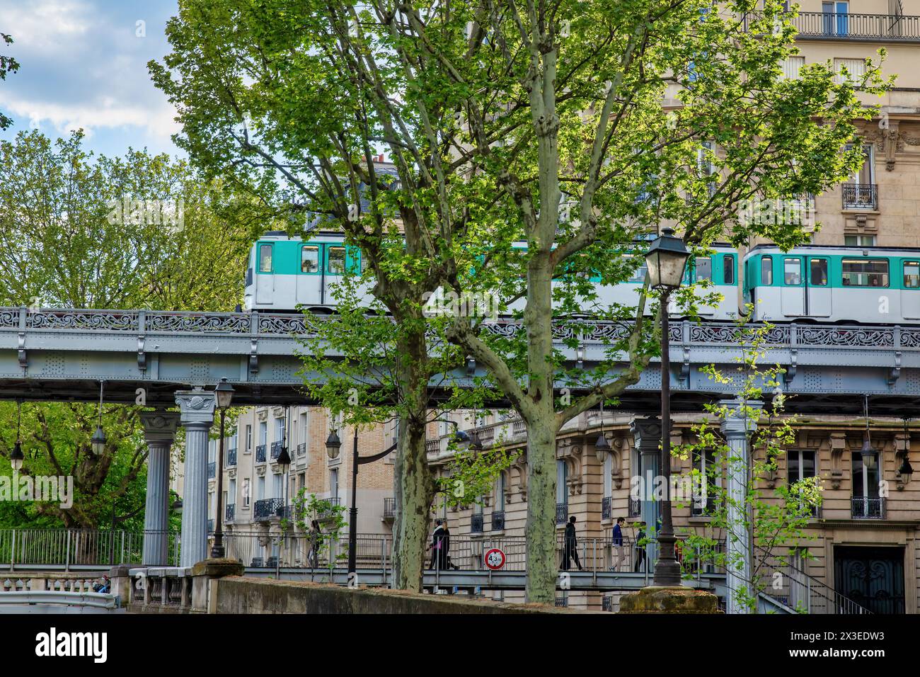 Il ponte di metallo attraversato dalla metropolitana di Parigi nel quartiere urbano. Primavera... Foto Stock