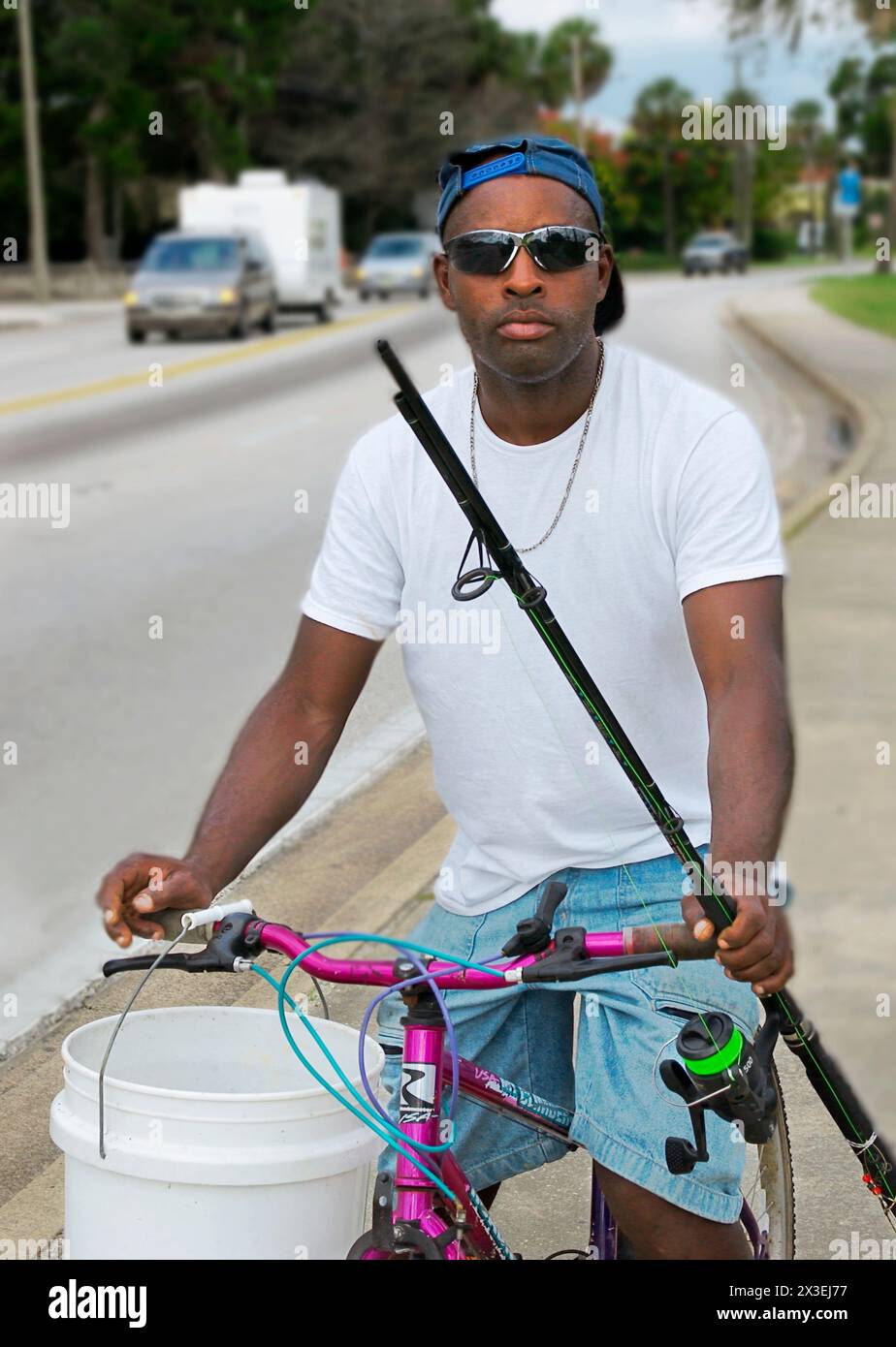 Un uomo afroamericano in bicicletta va a pescare a Saint Augustine, Florida, Stati Uniti. Foto Stock