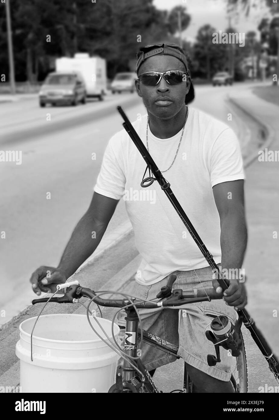 Un uomo afroamericano in bicicletta va a pescare a Saint Augustine, Florida USA. Foto Stock