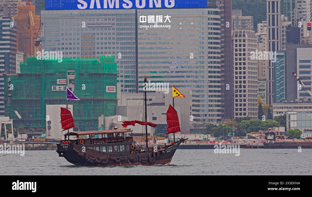 Hong Kong, Cina - 23 aprile 2017: Insegna bianca illuminata China Evergrande presso l'edificio degli uffici vista dal porto Victoria nella città di Hong Kong. Foto Stock
