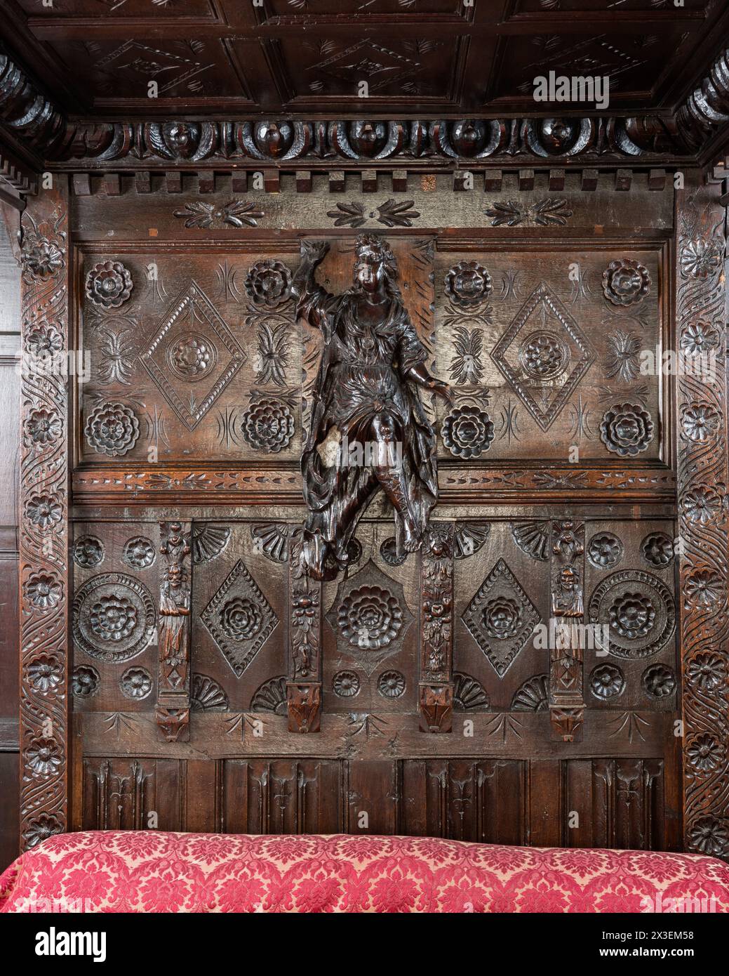 Testiera intagliata su letto a baldacchino nella Speke Hall, residenza Tudor del National Trust di grado i, Liverpool, Inghilterra, Regno Unito. Foto Stock