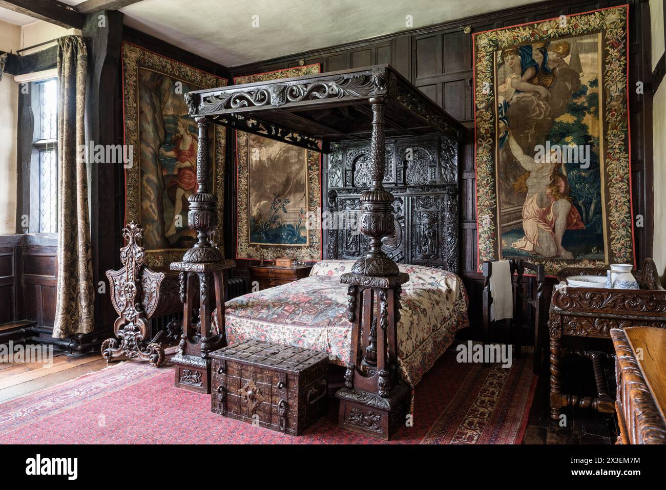 Antico letto a baldacchino e arazzi a parete a Speke Hall, residenza Tudor di grado i, Liverpool, Inghilterra, Regno Unito. Foto Stock