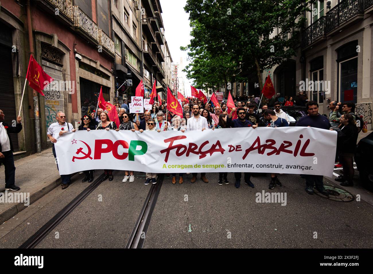 Porto, Portogallo. 25 aprile 2024. Militanti del Partito Comunista portoghese visti con un cartello che dice "forza d'aprile”, durante la parata che segna il 50° anniversario della Rivoluzione dei garofani. Migliaia di persone hanno partecipato alle celebrazioni del 50° anniversario del 25 aprile a Porto. Il 25 aprile 1974, una rivoluzione militare, nota come rivoluzione dei garofani, pose fine alla dittatura dell'Estado Novo, ripristinando la democrazia in Portogallo. Da allora questo giorno è stato celebrato come giorno della libertà. (Foto di Telmo Pinto/SOPA Images/Sipa USA) credito: SIPA USA/Alamy Live News Foto Stock