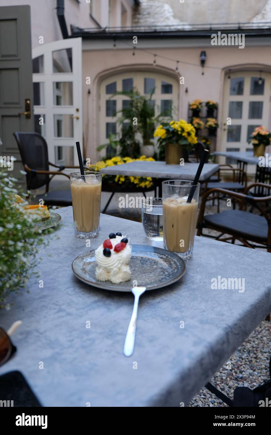 Una torta e un caffè ghiacciato in un caffè durante una bella giornata estiva Foto Stock
