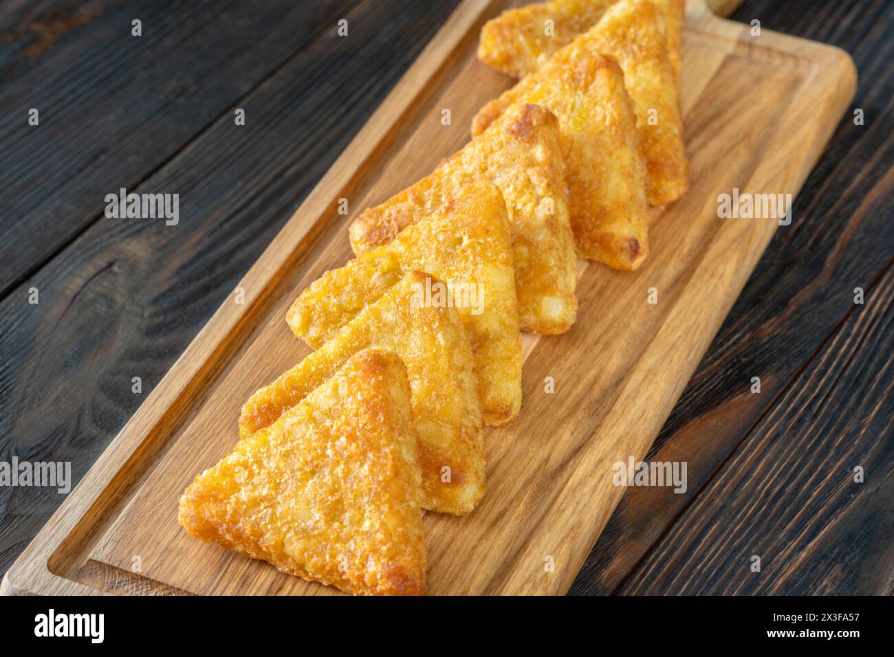 Hash Browns polpette triangolari sul tagliere Foto Stock