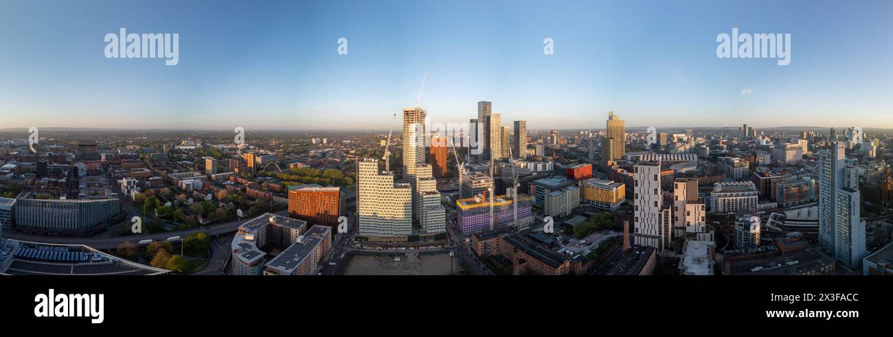 Il paesaggio urbano di Manchester mostra i grattacieli torreggianti vicino a piazza Deansgate sotto il cielo azzurro, riflettendo la crescita urbana Foto Stock