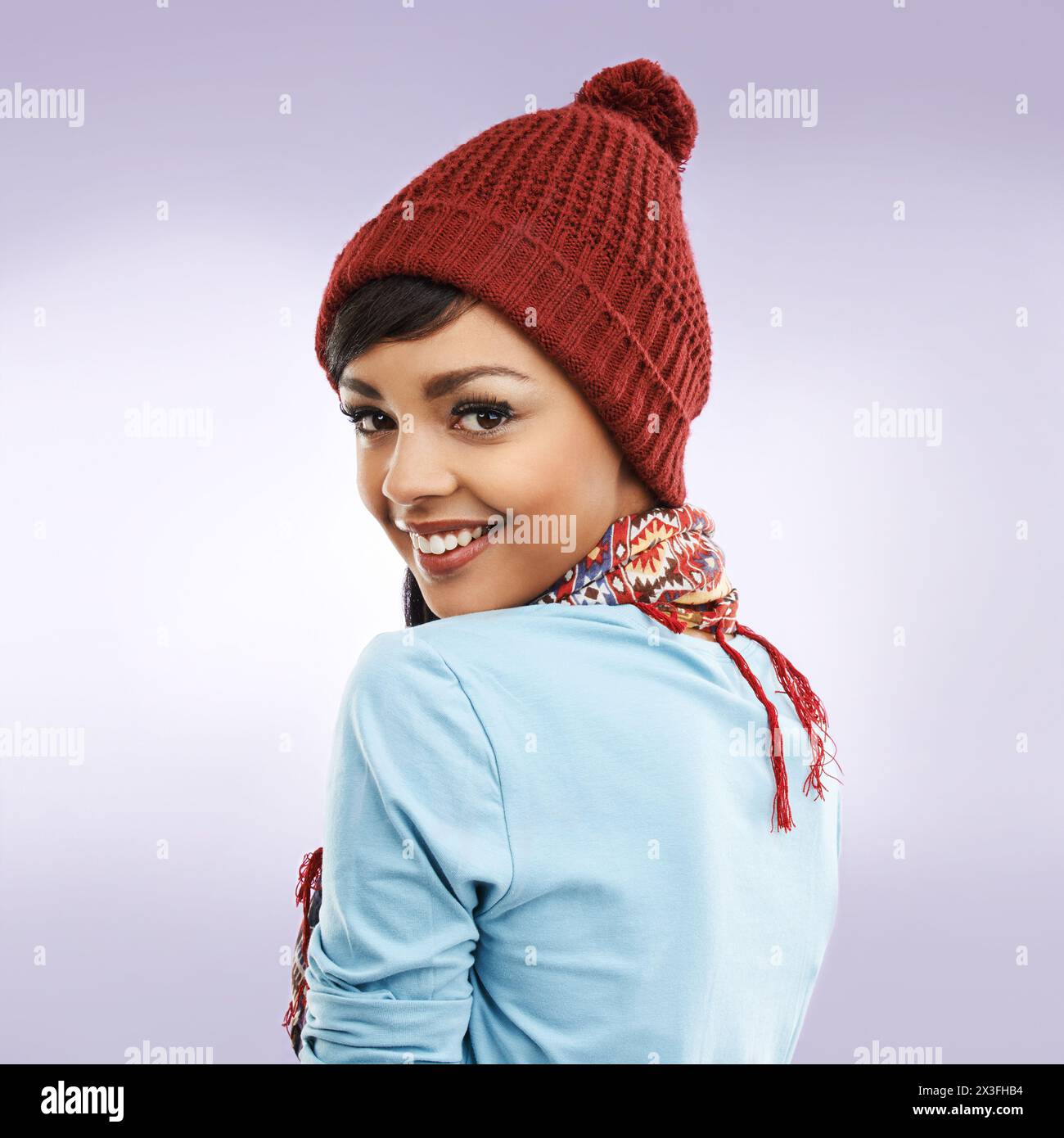 Moda, donna e ritratto in inverno, studio con sciarpa per un caldo sfondo colorato. Accessori, abbigliamento e capsula guardaroba con berretto per il freddo Foto Stock