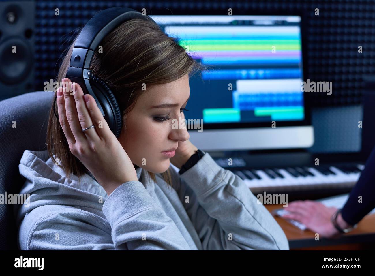 Penosa art Director femminile in cuffie che ascolta la musica in studio Foto Stock