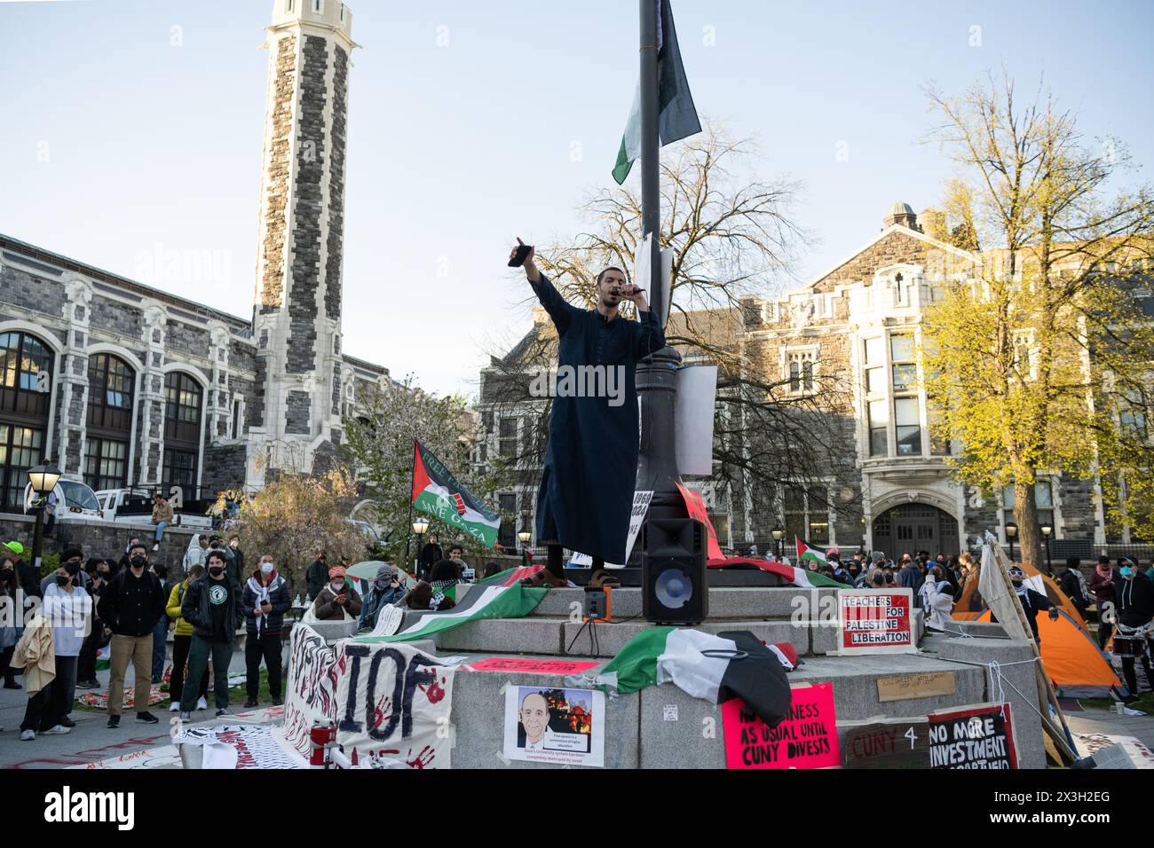 Un manifestante guida la folla in canti di protesta all'accampamento del City College di New York. Foto Stock