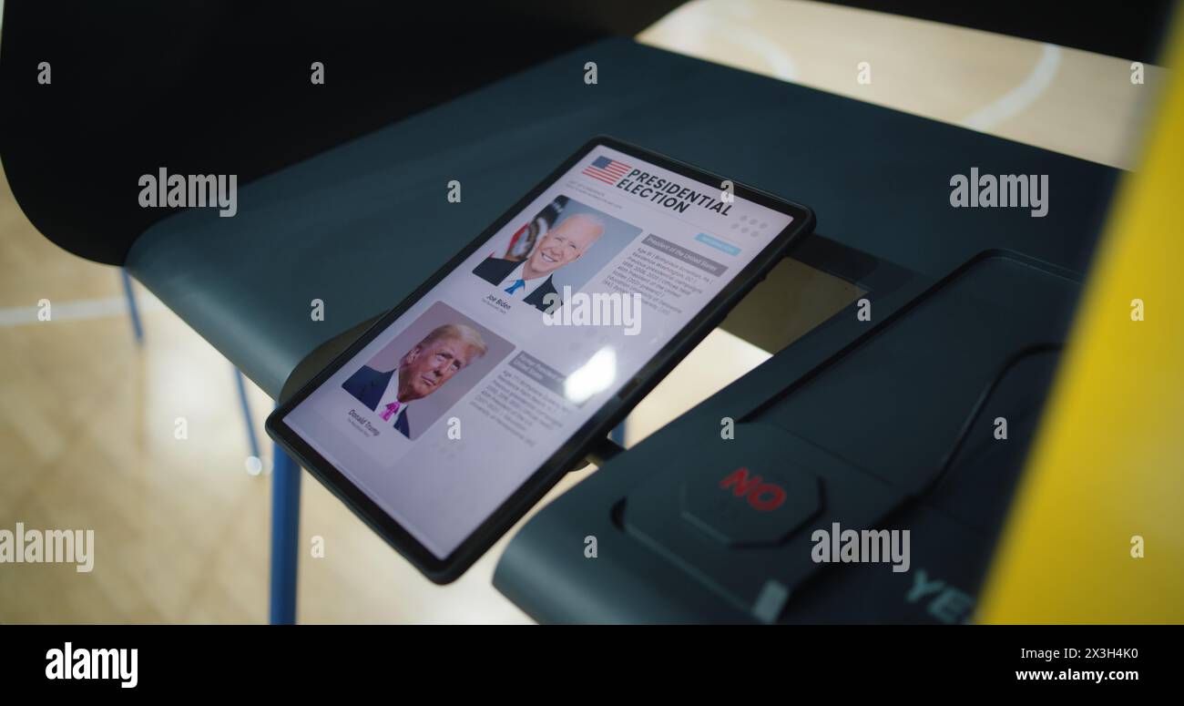 ZAPORIZHYA, UCRAINA - 15 MARZO 2024: Cabina di votazione presso la stazione di poling con tablet. Elenco dei candidati presidenziali statunitensi visualizzato sullo schermo. Moderna tecnologia di voto digitale. Giornata nazionale delle elezioni negli Stati Uniti d'America. Foto Stock