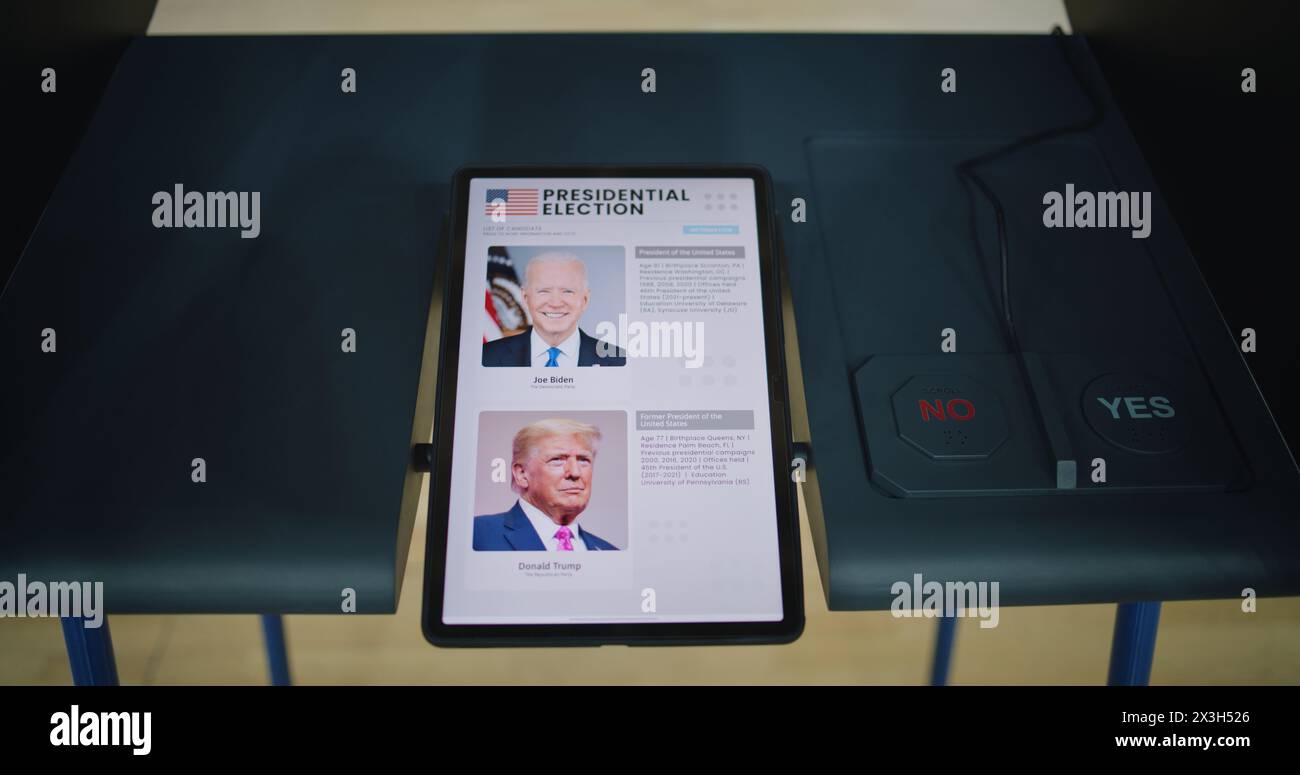 ZAPORIZHYA, UCRAINA - 15 MARZO 2024: Cabina di votazione presso la stazione di poling con tablet. Elenco dei candidati presidenziali statunitensi visualizzato sullo schermo. Moderna tecnologia di voto digitale. Giornata nazionale delle elezioni negli Stati Uniti d'America. Foto Stock