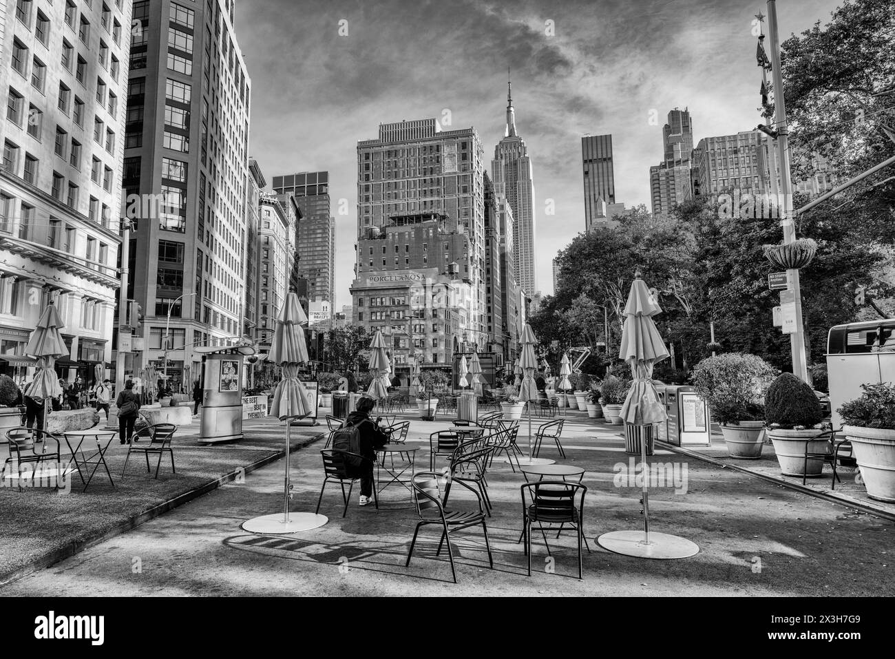 Lone Person in Worth Square, Midtown, vicino a edifici storici con il grattacielo Art Deco Empire State Building sulla 5th Avenue dietro Manhattan, New York. Foto Stock