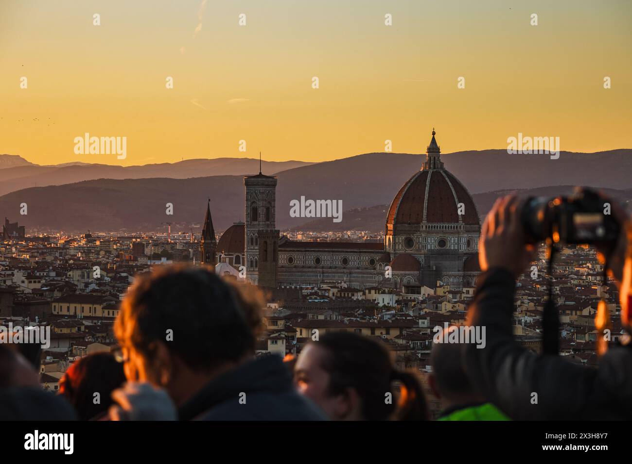 Folle che scattano fotografie del Duomo di Firenze da Piazzale Michelangelo, un classico luogo al tramonto che soffre di overturismo. Foto Stock