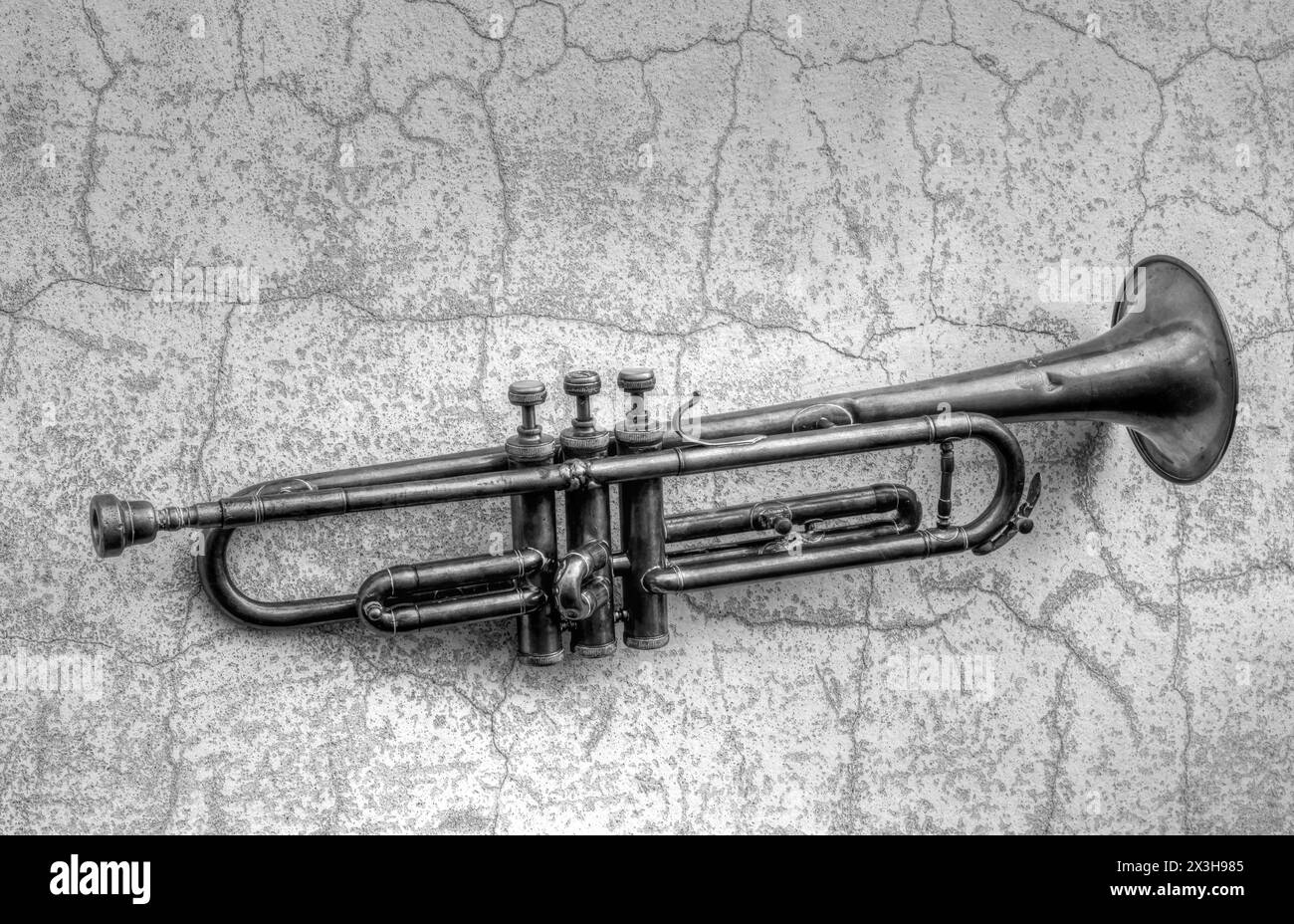 Una tromba Jazz antica su un vecchio muro in bianco e nero Foto Stock