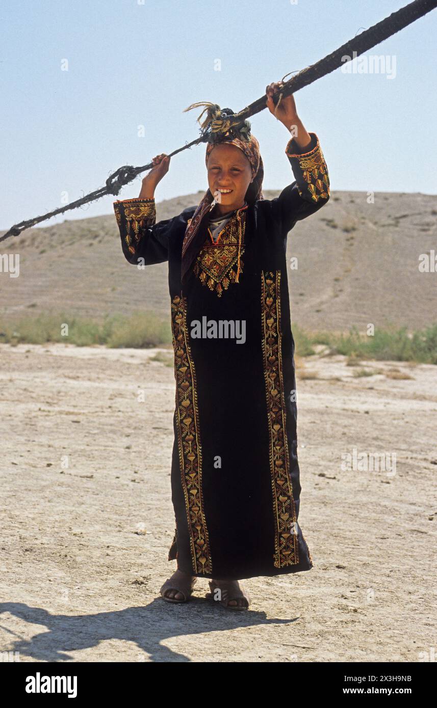 Beduina in piedi con abiti tradizionali vicino alla sua tenda Foto Stock