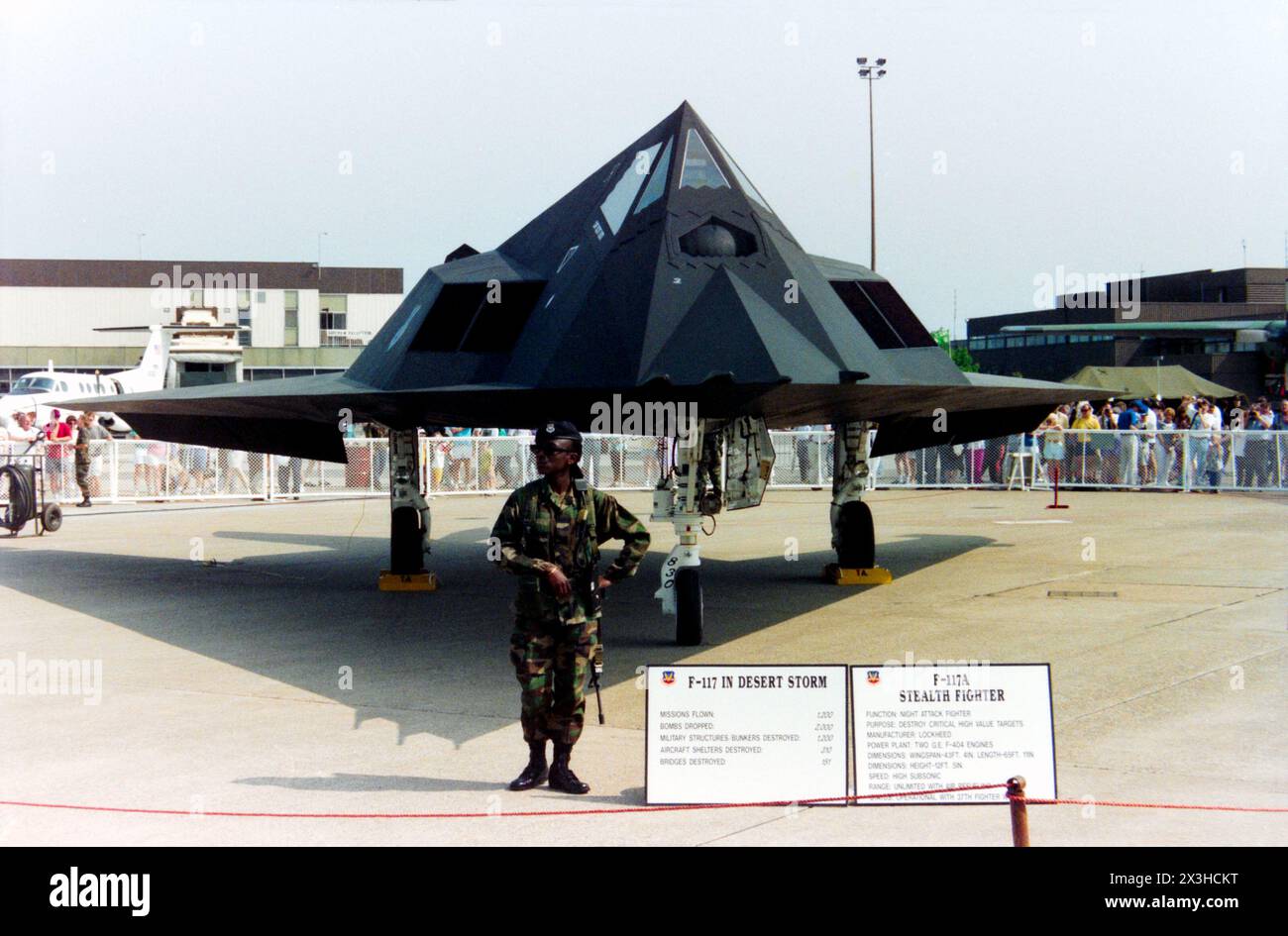 Lockheed F-117A Nighthawk "Stealth Fighter" 85-0830 in mostra con guardia armata e statistiche sulla Guerra del Golfo presso la Mildenhall Air Fete 1992. Questa fu la prima apparizione pubblica del Lockheed nel Regno Unito dopo la copertura mediatica mondiale delle capacità notturne del caccia-bombardiere durante l'operazione Desert Storm della Guerra del Golfo. L'USAF utilizzò l'F-117 per bombardare obiettivi importanti come bunker e rifugi per aerei, come elencato sulla bacheca. Guardia armata femminile. Dal 37th Tactical Fighter Wing USAF questo aereo ha volato una serie di missioni durante la campagna Foto Stock