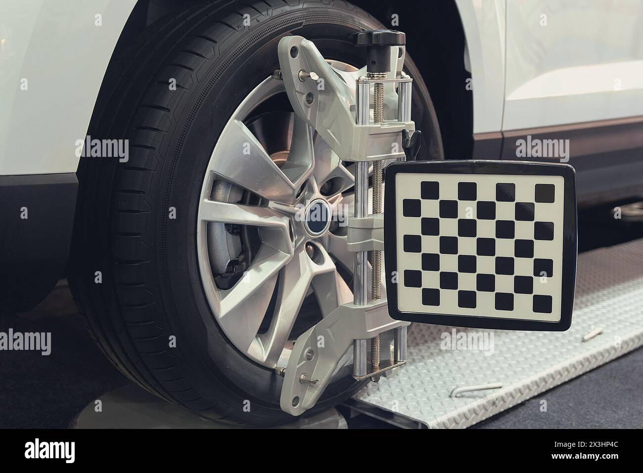 Attrezzatura di allineamento delle ruote su una ruota di un'auto in una stazione di riparazione. Industria Foto Stock