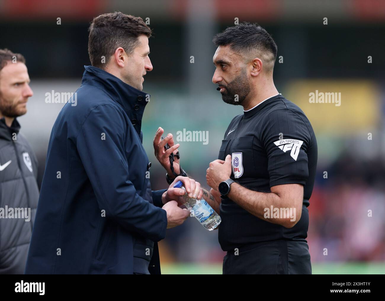 Il manager del Portsmouth John Mousinho viene avvertito dall'arbitro Sunny Singh Gill durante la partita Sky Bet League One al LNER Stadium di Lincoln. Data foto: Sabato 27 aprile 2024. Foto Stock