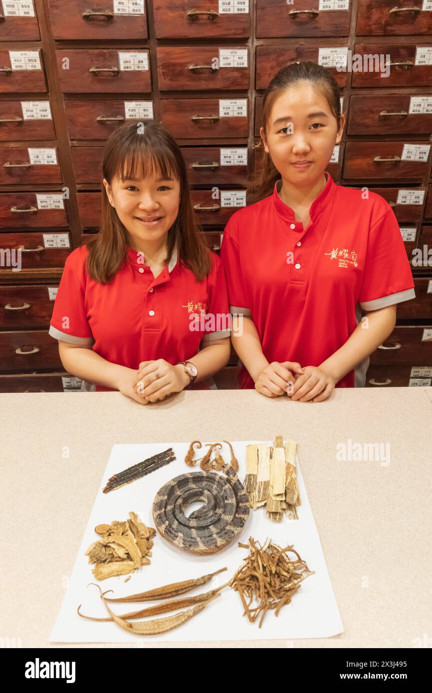 Asia, Singapore, Chinatown, Chinese Herbal Medicine Store, Sales Girls con esposizione di prodotti Herbal Medicine Foto Stock