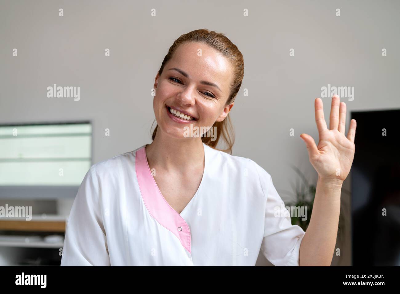 Concetto di telemedicina. Una donna medico onora e sorride a un paziente durante una videochiamata. Foto Stock
