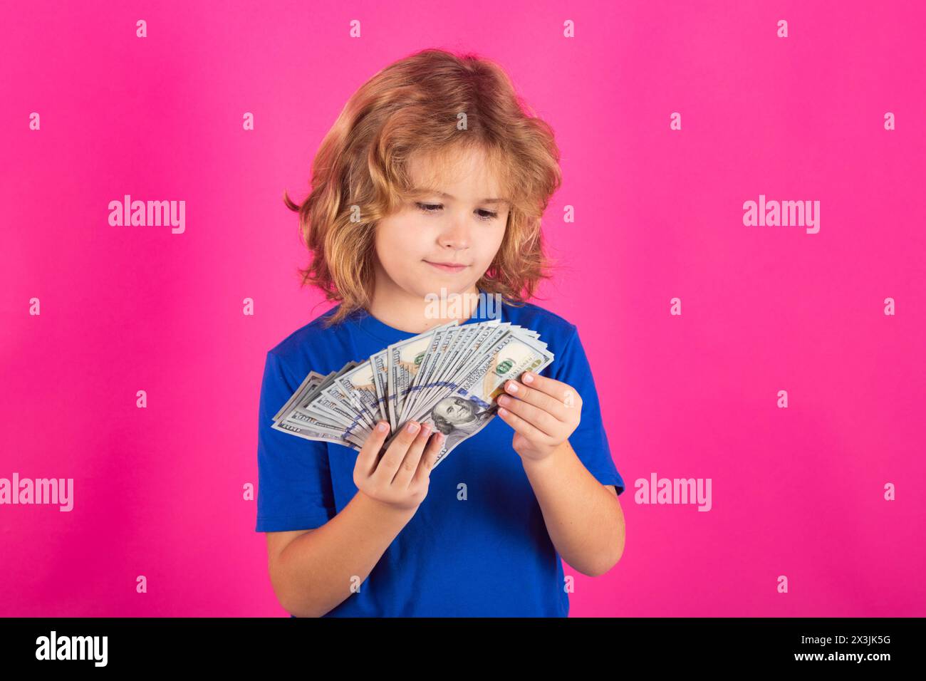 I soldi vincono, grande fortuna. Ragazzo che mostra banconote da soldi, sogna di ricchi su un ambiente isolato in studio Foto Stock