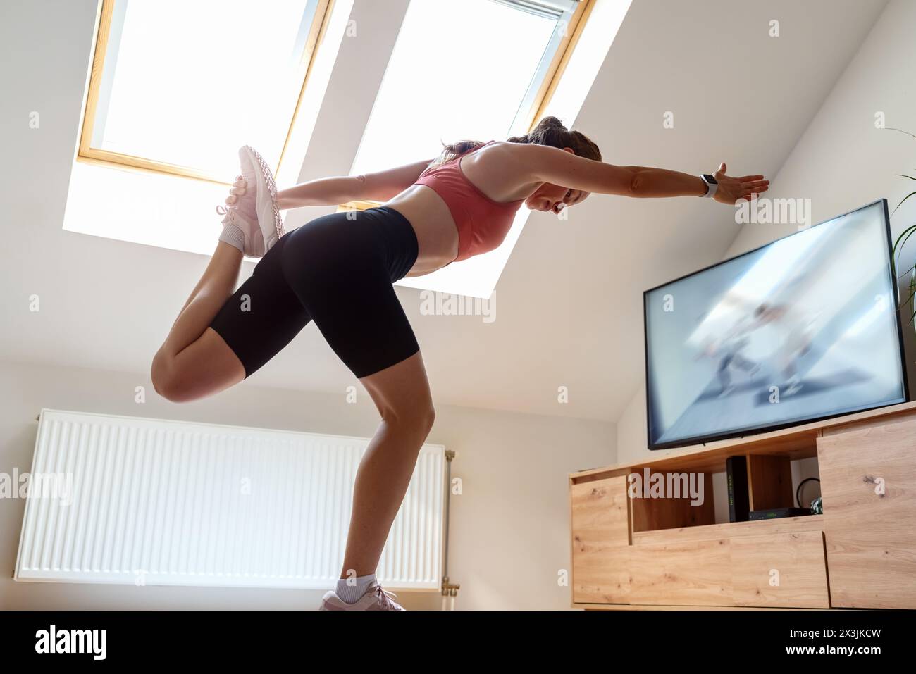 Corsi di allenamento online. Atletica che si allena a casa con lezioni di video sport in TV. Foto Stock