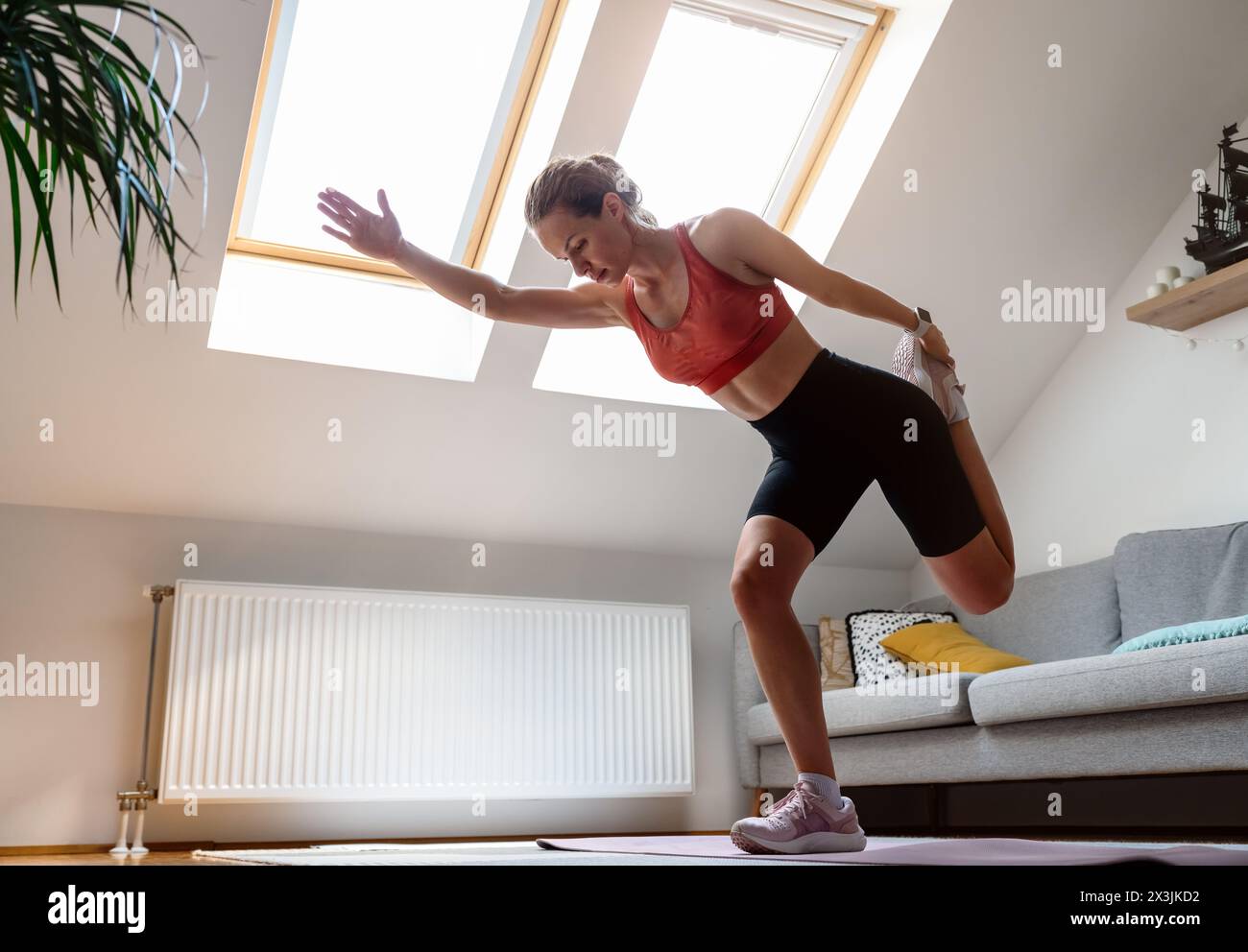 Donna atletica attraente che indossa abbigliamento sportivo per allenarsi a casa. Foto Stock