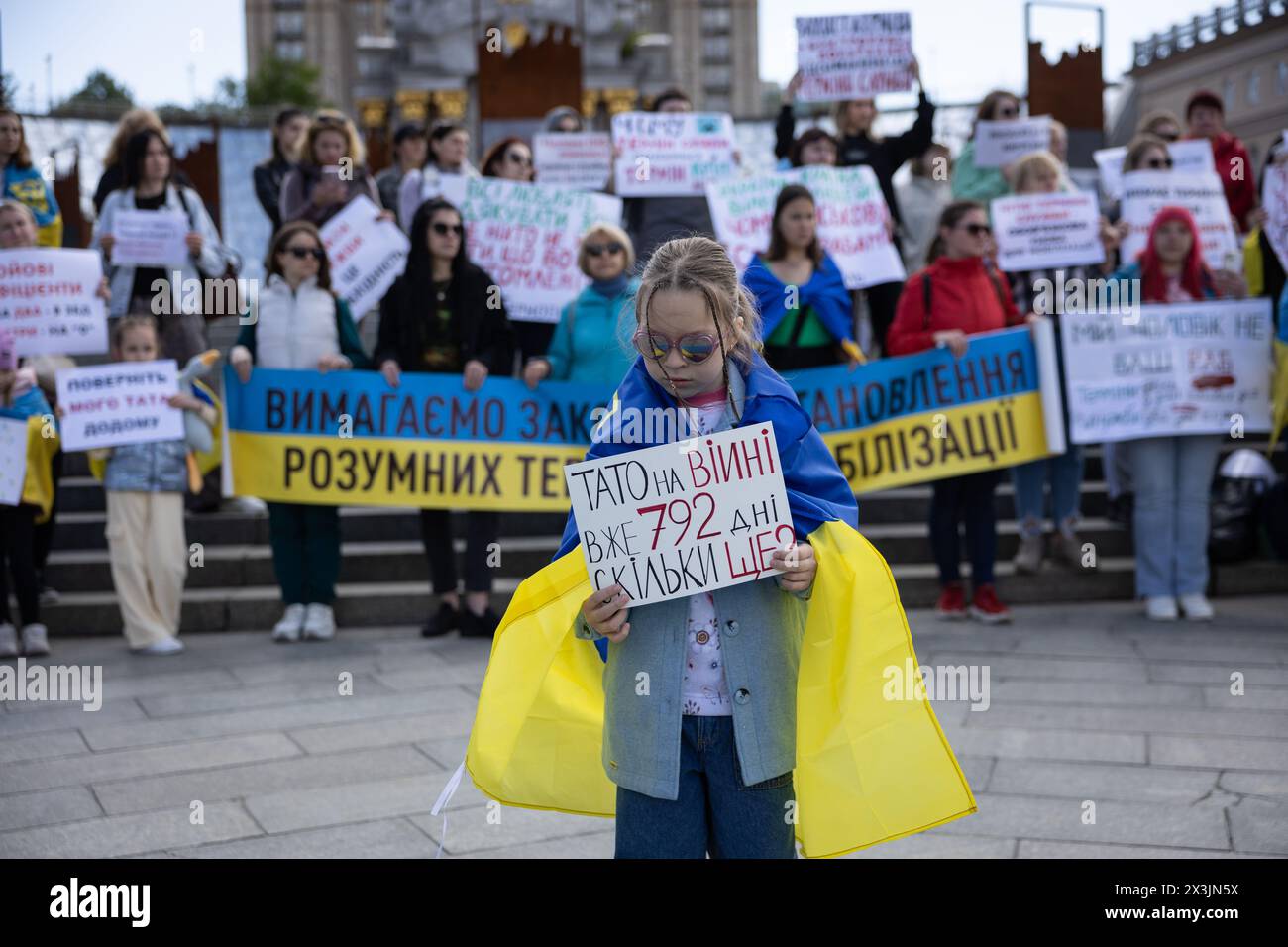 Kiev, Ucraina. 27 aprile 2024. Una ragazza ha un cartello che dice: "Papà è già in guerra da 792 giorni. Quanto ancora?" Mentre prende parte a un raduno che chiede l'istituzione di termini di smobilitazione, presso la Piazza dell'indipendenza a Kiev. La gente si riunì per chiedere i termini di durata del servizio nell'esercito, di essere in prima linea, e di una rotazione equa. Le condizioni di smobilitazione non sono previste da una nuova legge sulla mobilitazione adottata dal Parlamento ucraino e firmata di recente dal Presidente Zelensky. (Foto di Oleksii Chumachenko/SOPA Images/Sipa USA) credito: SIPA USA/Alamy Live News Foto Stock