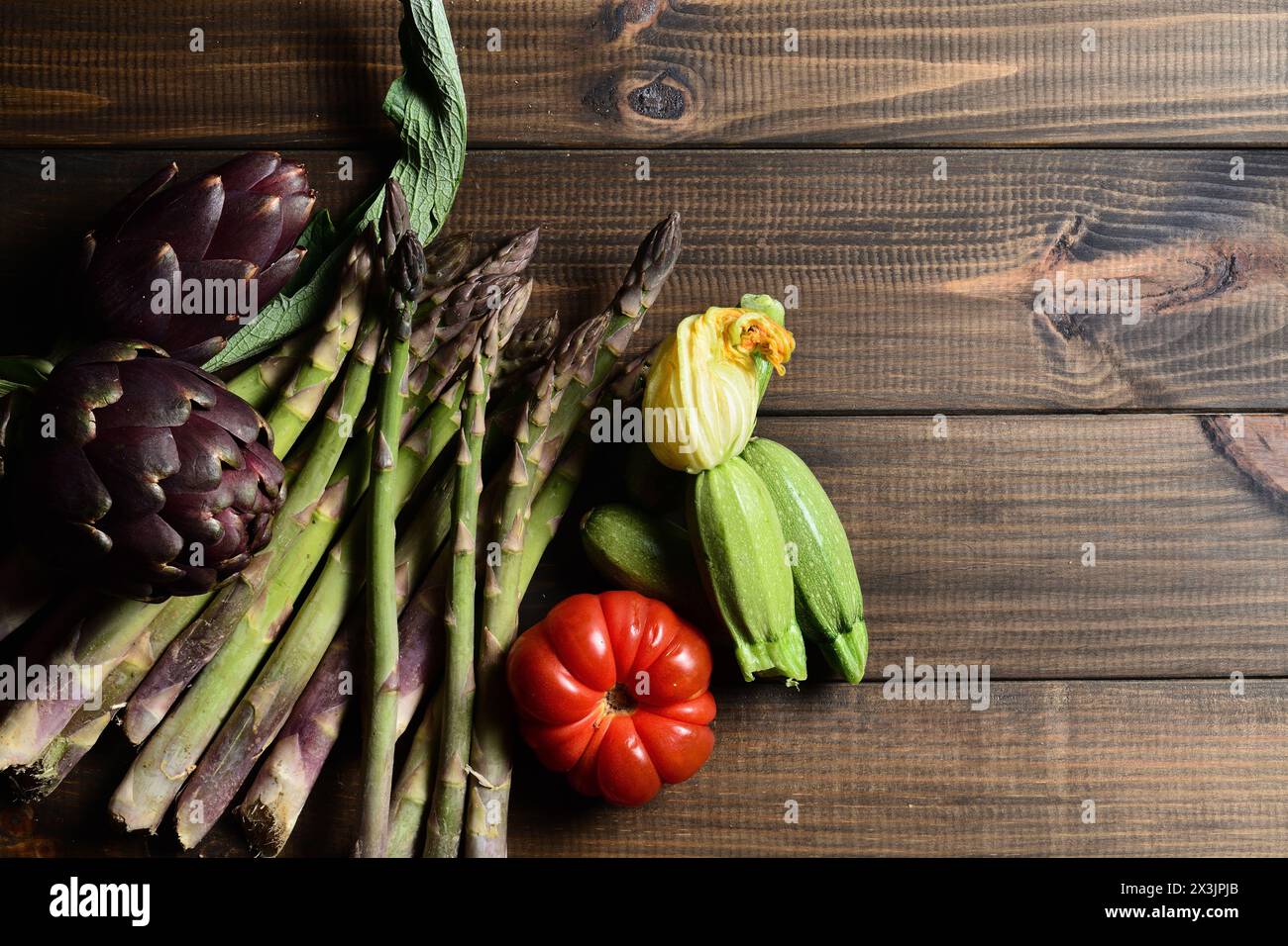 Verdure biologiche su un asse di legno. Foto Stock