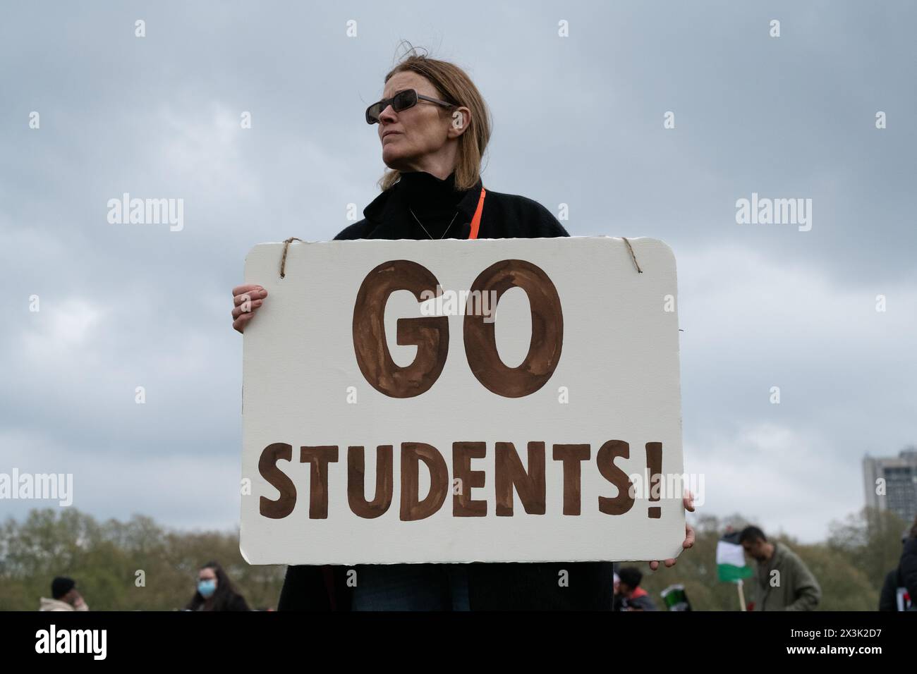 Londra, Regno Unito. 27 aprile 2024. Una donna ha un cartello con scritto "Vai studenti!" - Un riferimento alle proteste studentesche pesantemente sorvegliate negli Stati Uniti - mentre grandi folle di sostenitori palestinesi si radunano a Hyde Park chiedendo un cessate il fuoco e la fine del sostegno del Regno Unito e degli Stati Uniti all'assedio, al bombardamento e all'invasione di Gaza da parte di Israele a seguito di un attacco di militanti di Hamas. La protesta è stata la tredicesima marcia nazionale contro la guerra di Israele a Gaza, iniziata nell'ottobre 2023 ed è stata descritta dallo studioso dell'Olocausto Raz Segal come un "caso da manuale di genocidio”. Crediti: Ron Fassbender/Alamy Live News Foto Stock