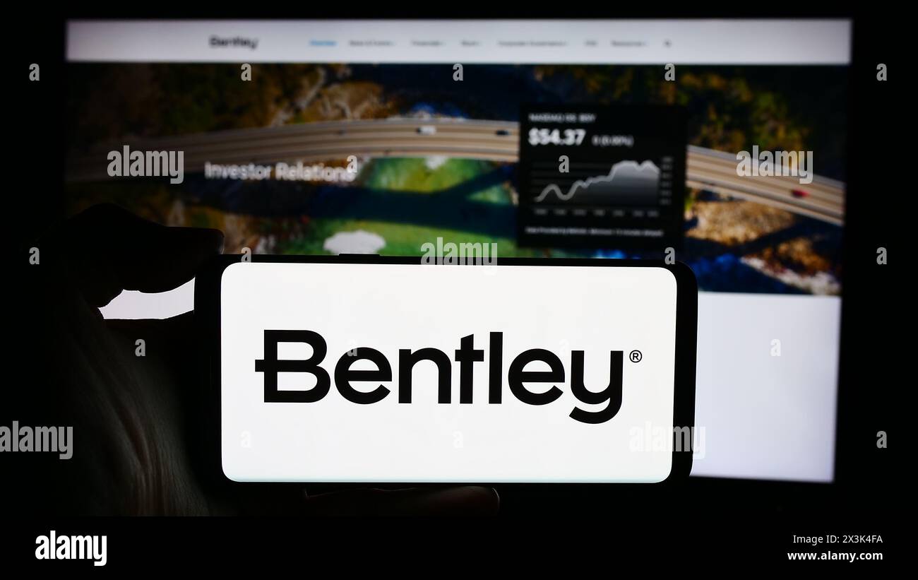 Persona che detiene un cellulare con il logo della società di software statunitense Bentley Systems Inc. Di fronte alla pagina Web aziendale. Mettere a fuoco il display del telefono. Foto Stock