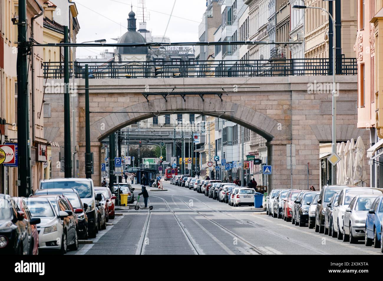 Via Sokolovska a Praga con il suo iconico ponte ad arco e le linee del tram, animata dalla vita urbana. Foto Stock