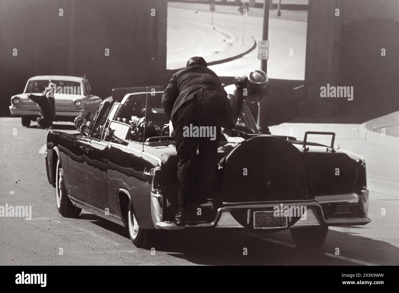 Il presidente John F. Kennedy cadde sul sedile posteriore della sua auto da corsa dopo essere stato ucciso a Dallas, Texas, il 22 novembre 1963. La First Lady Jaqueline Kennedy si appoggia al Presidente mentre un uomo dei servizi segreti va in suo aiuto. (USA) Foto Stock