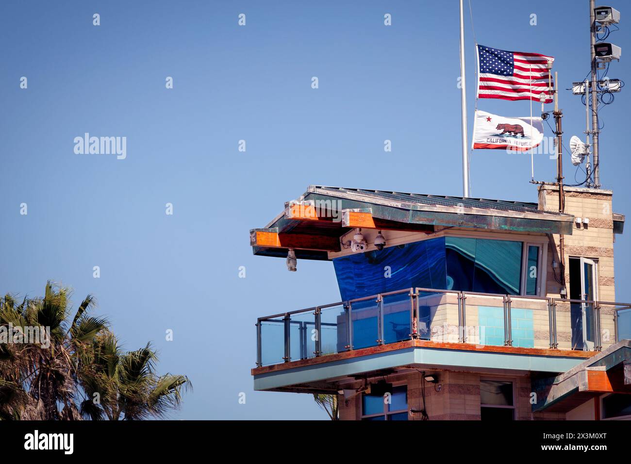Le bandiere volano a mezz'asta sopra la stazione dei bagnini di Imperial Beach, California. Foto Stock