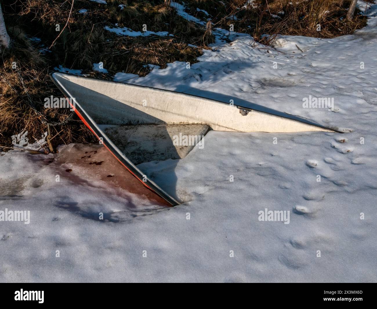 barca sepolta sotto la neve e il ghiaccio sulla riva Foto Stock