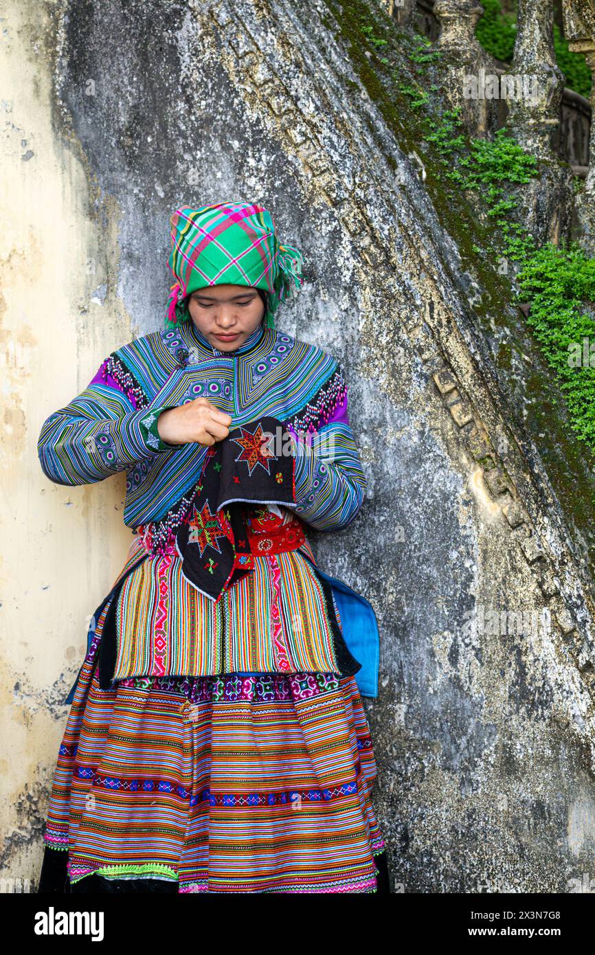 Donna Hmong di fiori che fa ricami al Palazzo dei Re Hmong (Vau Meo) a Bac ha, provincia di Lao Cai, Vietnam Foto Stock