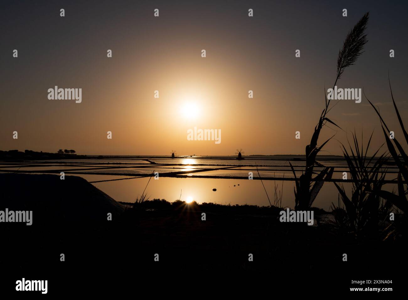 Saline con mulini a vento al tramonto Foto Stock