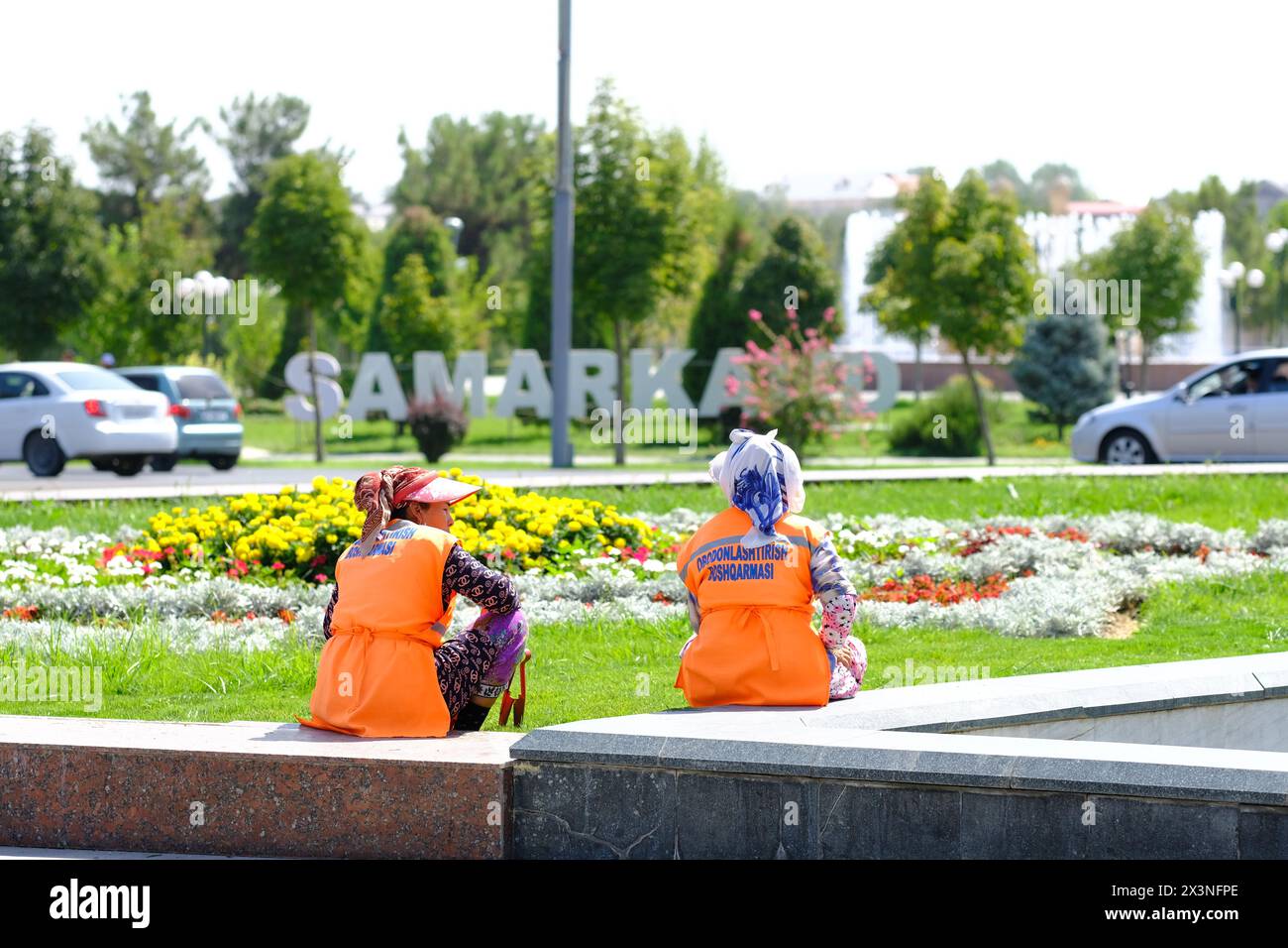 Samarcanda Uzbekistan - il personale di giardino si prende una pausa mentre lavora su aiuole di fiori a Samarqand nell'agosto 2022 Foto Stock